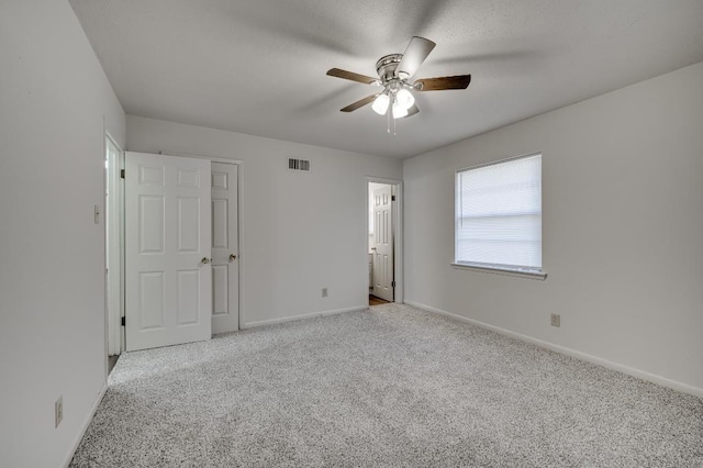 carpeted spare room with ceiling fan