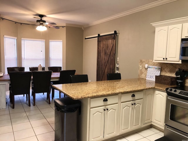 kitchen featuring light tile patterned flooring, white cabinetry, stainless steel range with electric stovetop, kitchen peninsula, and a barn door