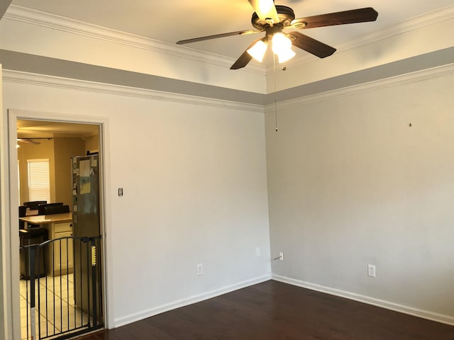 empty room featuring dark wood-type flooring, ceiling fan, and ornamental molding