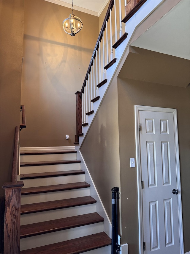 stairs featuring crown molding and a notable chandelier