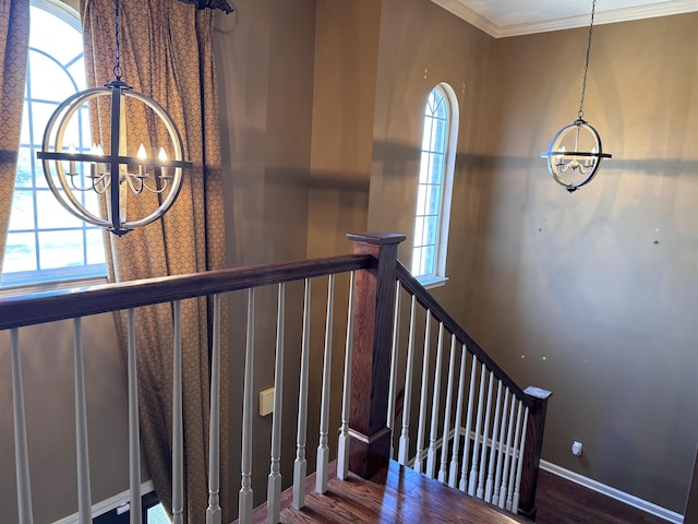 stairs featuring crown molding and a chandelier