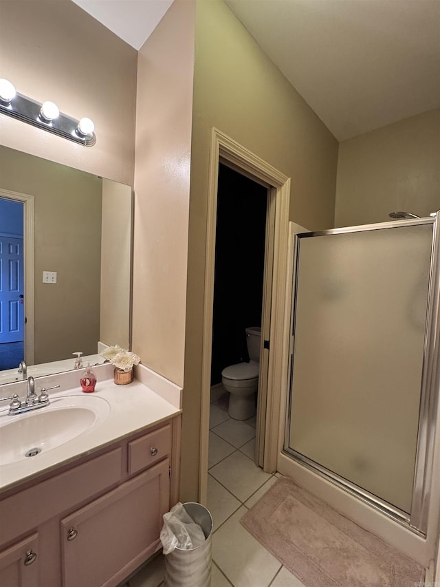 bathroom featuring vanity, a shower with shower door, tile patterned floors, and toilet