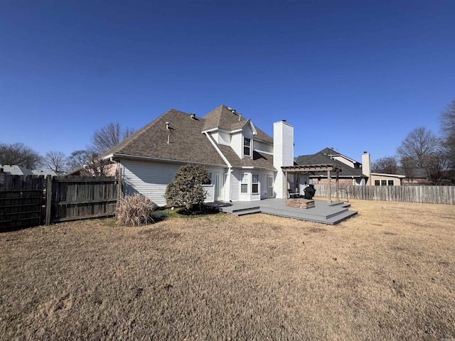 rear view of property featuring a yard, a pergola, and a deck