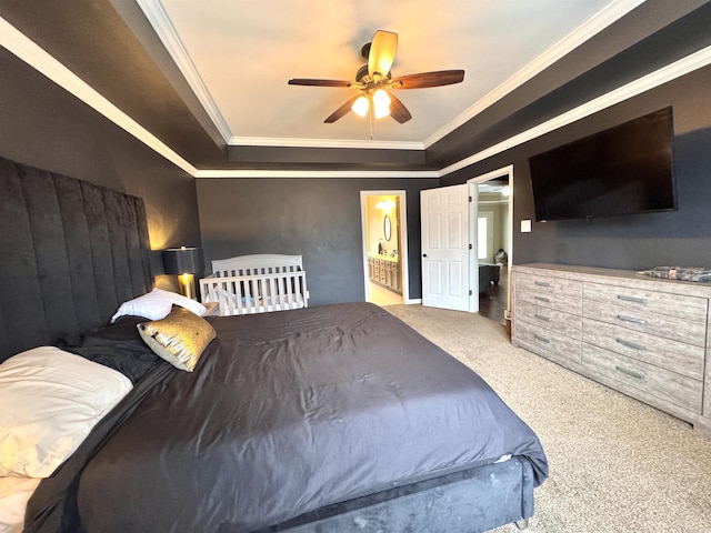 carpeted bedroom featuring ensuite bathroom, ceiling fan, a tray ceiling, and ornamental molding