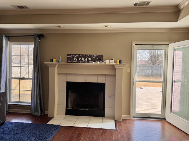 details with a tiled fireplace, hardwood / wood-style floors, and ornamental molding