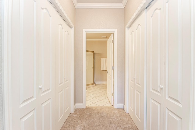 hallway with crown molding and light colored carpet