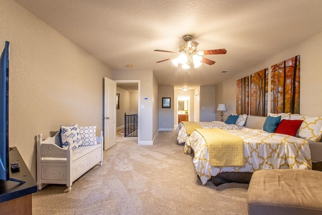 carpeted bedroom featuring ceiling fan, ensuite bath, and a textured ceiling