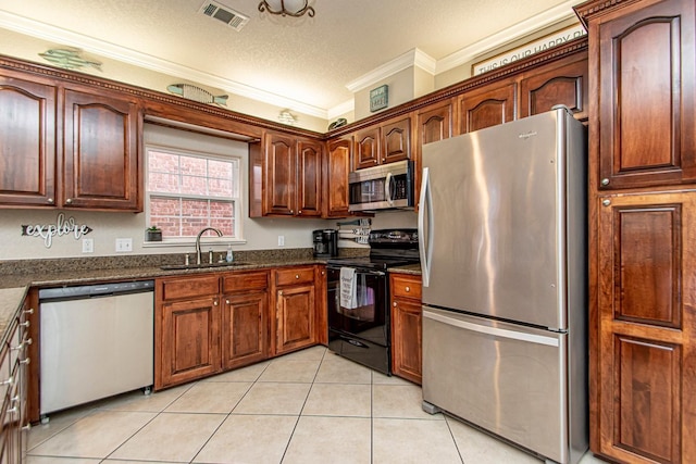 kitchen featuring sink, appliances with stainless steel finishes, ornamental molding, light tile patterned flooring, and dark stone counters