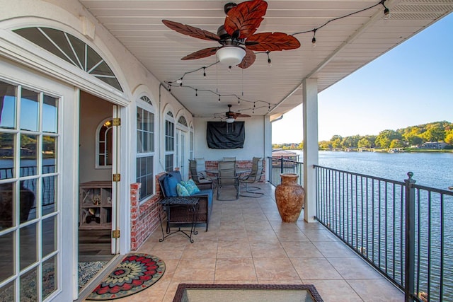 view of patio / terrace featuring a balcony, a water view, and ceiling fan