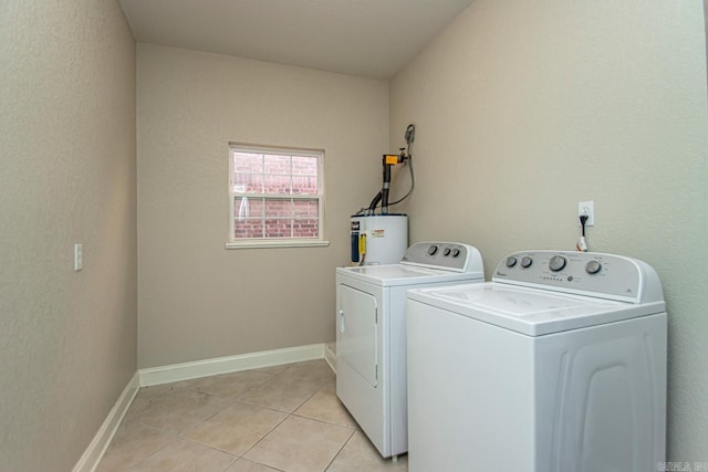 laundry room featuring washer and clothes dryer, water heater, and light tile patterned flooring