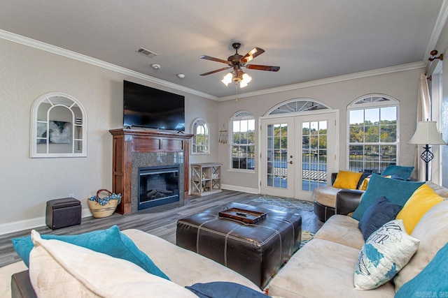 living room with french doors, a fireplace, crown molding, and hardwood / wood-style flooring