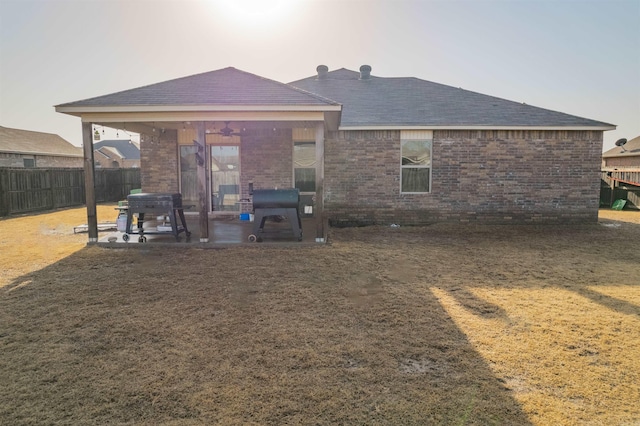 rear view of property featuring a yard and a patio area