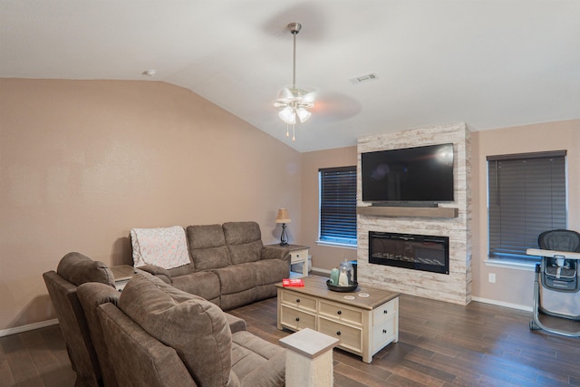 living room with lofted ceiling, a stone fireplace, dark hardwood / wood-style floors, and ceiling fan