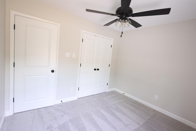 unfurnished bedroom with light colored carpet, a closet, and ceiling fan