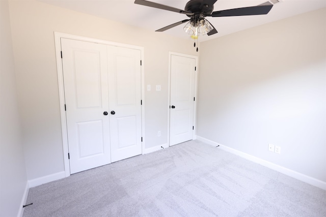 unfurnished bedroom with light carpet, ceiling fan, and a closet