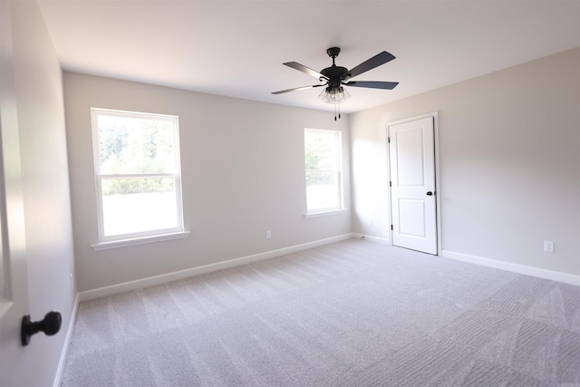 spare room with light colored carpet and ceiling fan