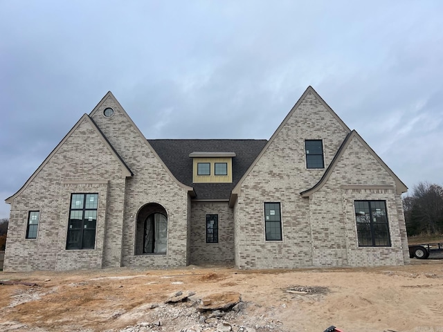 french provincial home featuring brick siding