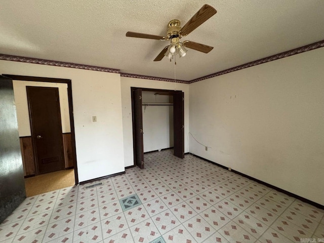 unfurnished bedroom featuring ceiling fan, ornamental molding, a closet, and a textured ceiling