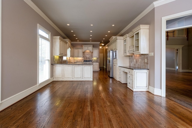 kitchen featuring crown molding, dark wood-type flooring, white cabinetry, stainless steel microwave, and tasteful backsplash