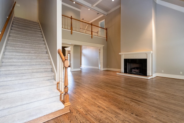 stairs featuring hardwood / wood-style floors and a towering ceiling