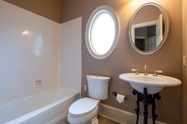 bathroom featuring toilet and a washtub