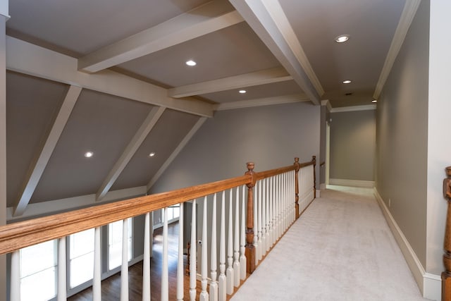 hallway with ornamental molding, carpet, and vaulted ceiling with beams