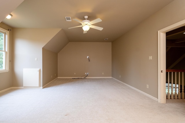 bonus room with vaulted ceiling, light colored carpet, and ceiling fan