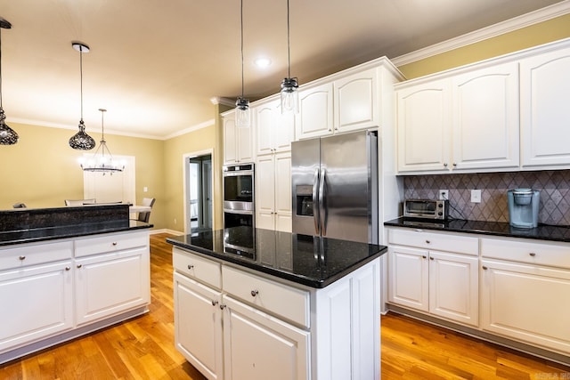 kitchen with white cabinetry, hanging light fixtures, a center island, stainless steel appliances, and crown molding