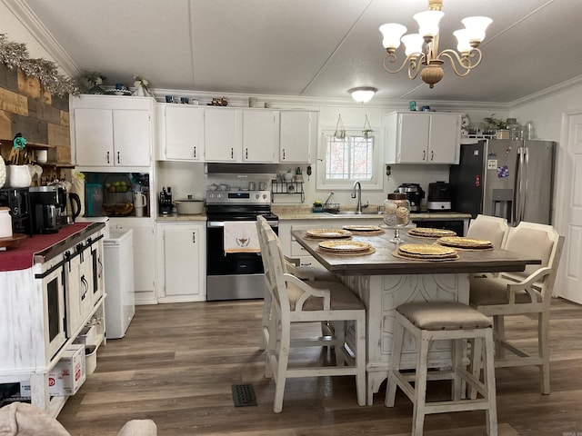 kitchen featuring white cabinetry, pendant lighting, ornamental molding, and appliances with stainless steel finishes