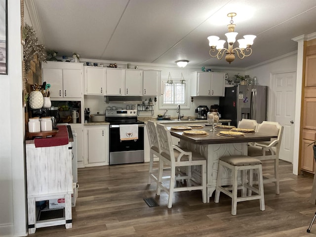 kitchen featuring crown molding, appliances with stainless steel finishes, white cabinets, dark hardwood / wood-style flooring, and decorative light fixtures