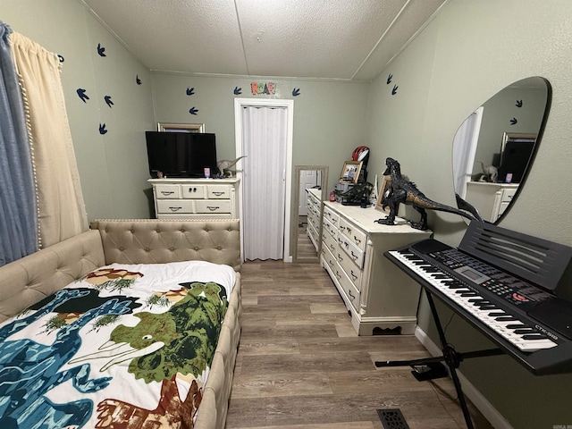 bedroom featuring light hardwood / wood-style floors and a textured ceiling