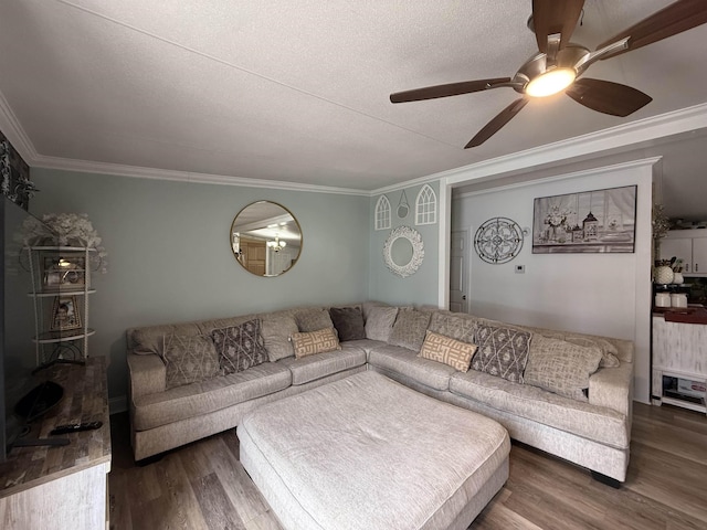 living room featuring ceiling fan, ornamental molding, dark hardwood / wood-style floors, and a textured ceiling