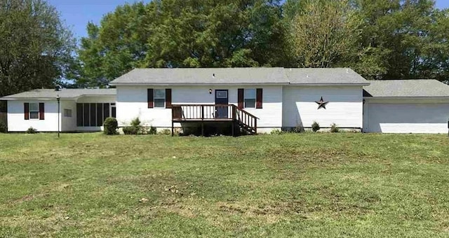 view of front facade featuring a yard, an attached garage, and a wooden deck