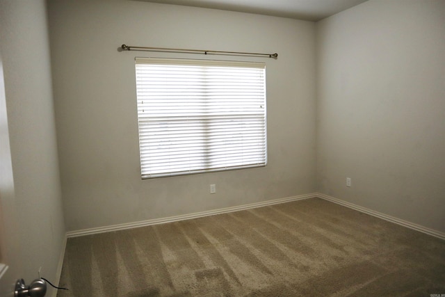 spare room with a wealth of natural light and dark carpet