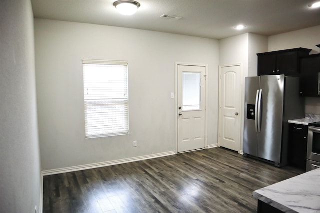 kitchen featuring light stone counters, appliances with stainless steel finishes, and dark hardwood / wood-style flooring