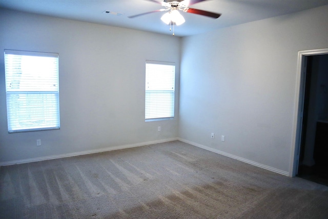 unfurnished room featuring dark carpet and ceiling fan