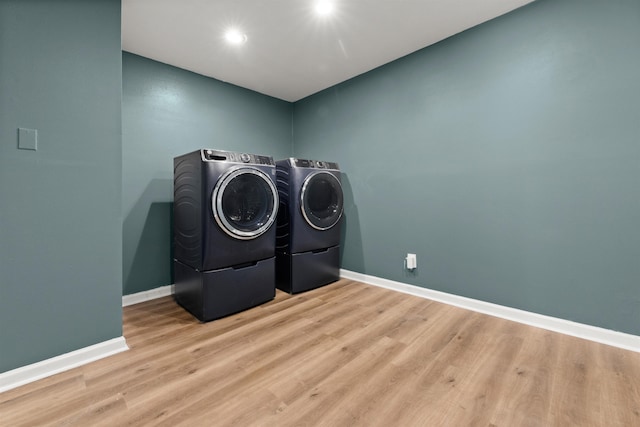 laundry area with separate washer and dryer and light wood-type flooring