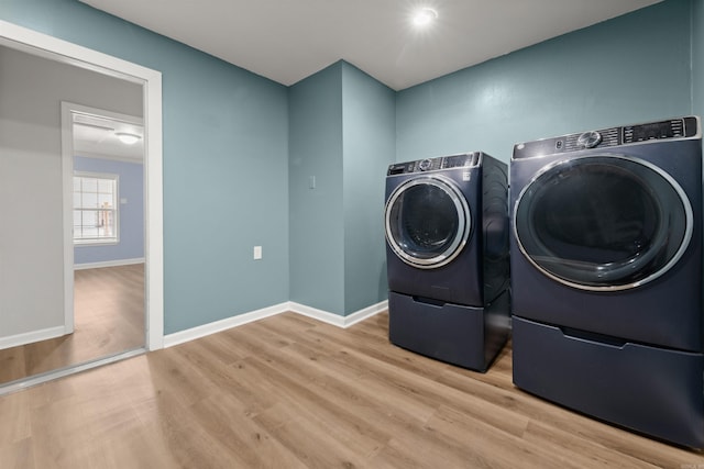 laundry room featuring washing machine and dryer and light hardwood / wood-style flooring