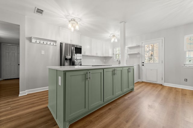 kitchen featuring stainless steel fridge, green cabinets, white cabinetry, a wealth of natural light, and a kitchen island