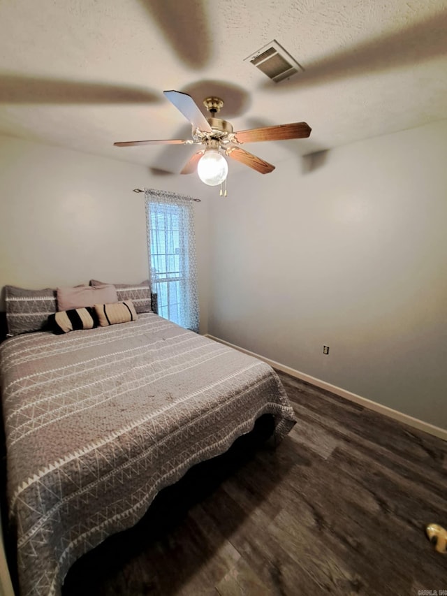 bedroom featuring hardwood / wood-style floors, a textured ceiling, and ceiling fan