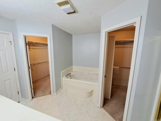 bathroom featuring a bath and a textured ceiling