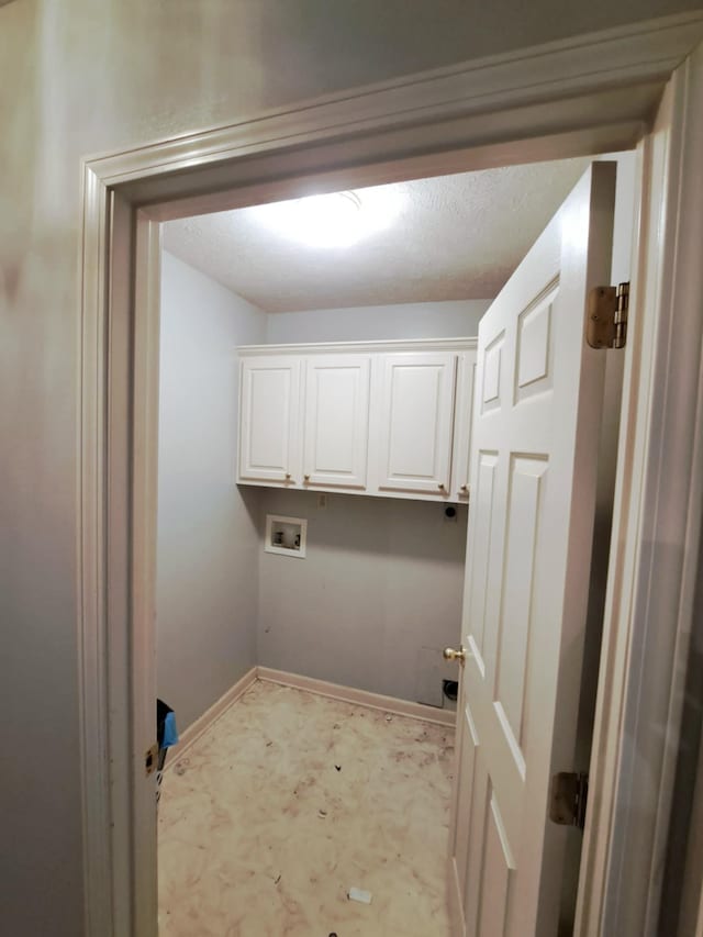 clothes washing area with cabinets, hookup for a washing machine, and a textured ceiling