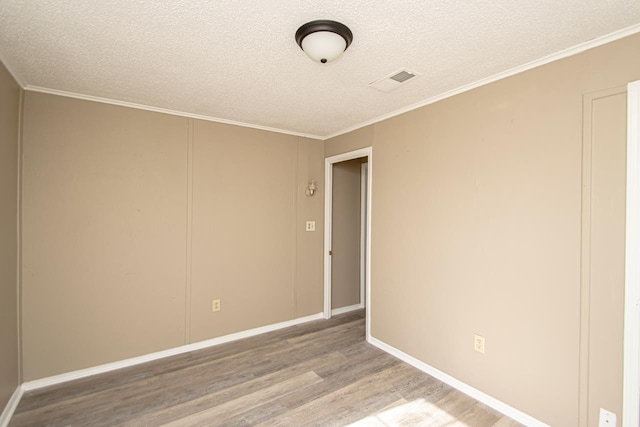 unfurnished room featuring ornamental molding, hardwood / wood-style floors, and a textured ceiling