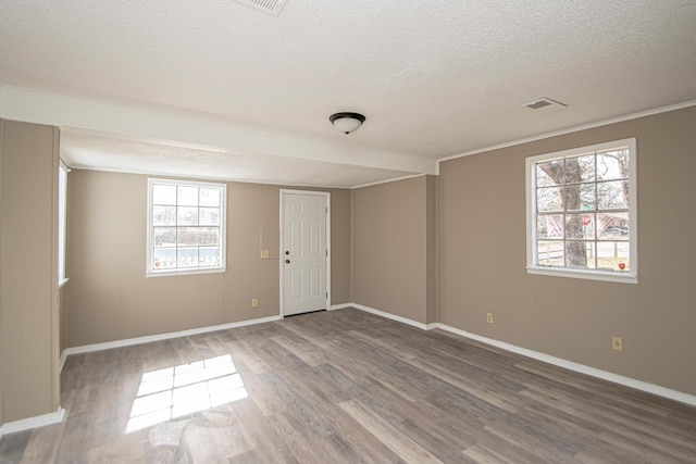 empty room with hardwood / wood-style flooring and a textured ceiling