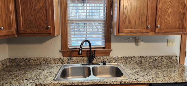 interior space with light stone countertops and sink