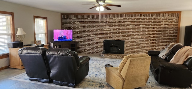 living room featuring ceiling fan, brick wall, and a fireplace