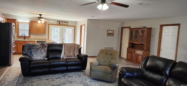 living room with french doors, ceiling fan, and sink