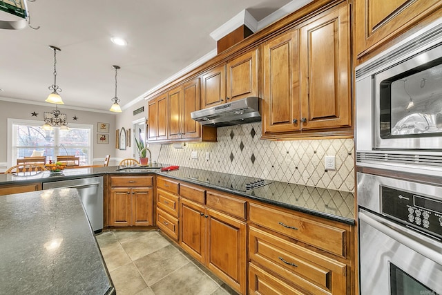 kitchen with stainless steel appliances, brown cabinetry, a sink, and under cabinet range hood