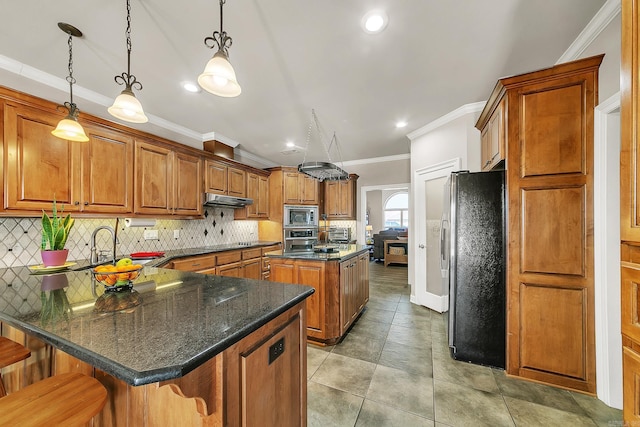 kitchen featuring appliances with stainless steel finishes, brown cabinets, and under cabinet range hood