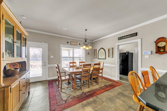 dining room with a notable chandelier, ornamental molding, visible vents, and tile patterned floors